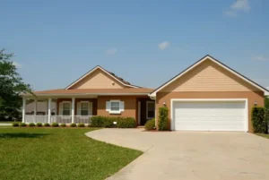 Single-story beige house with a front porch and attached garage.